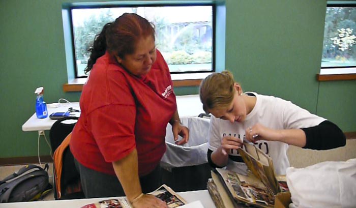 Albums with pages that are stuck together were sifted through as members of the community slowly but steadily stopped by the African America Museum of Iowa to visit Operation Photo Rescue and see what could be done to restore their photographs.